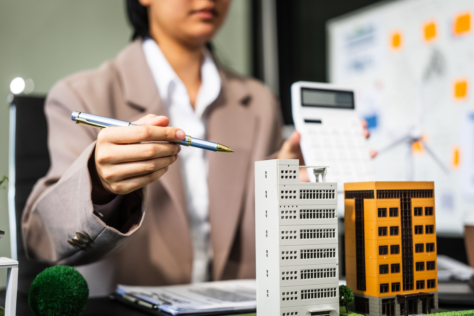 A young businesswoman is working at her desk, managing legal matters related to real estate, including leases and renovations, while ensuring compliance with laws and regulations.
